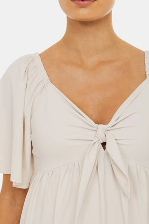 Sukienka ciążowa z marszczeniami i kokardą – jasnobeżowa